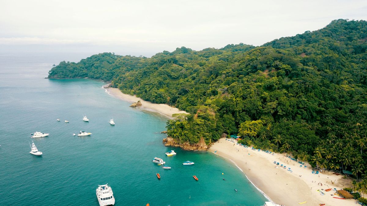 Aerial view of a tropical bay in Costa Rica with fishing boats and lush green hillsides