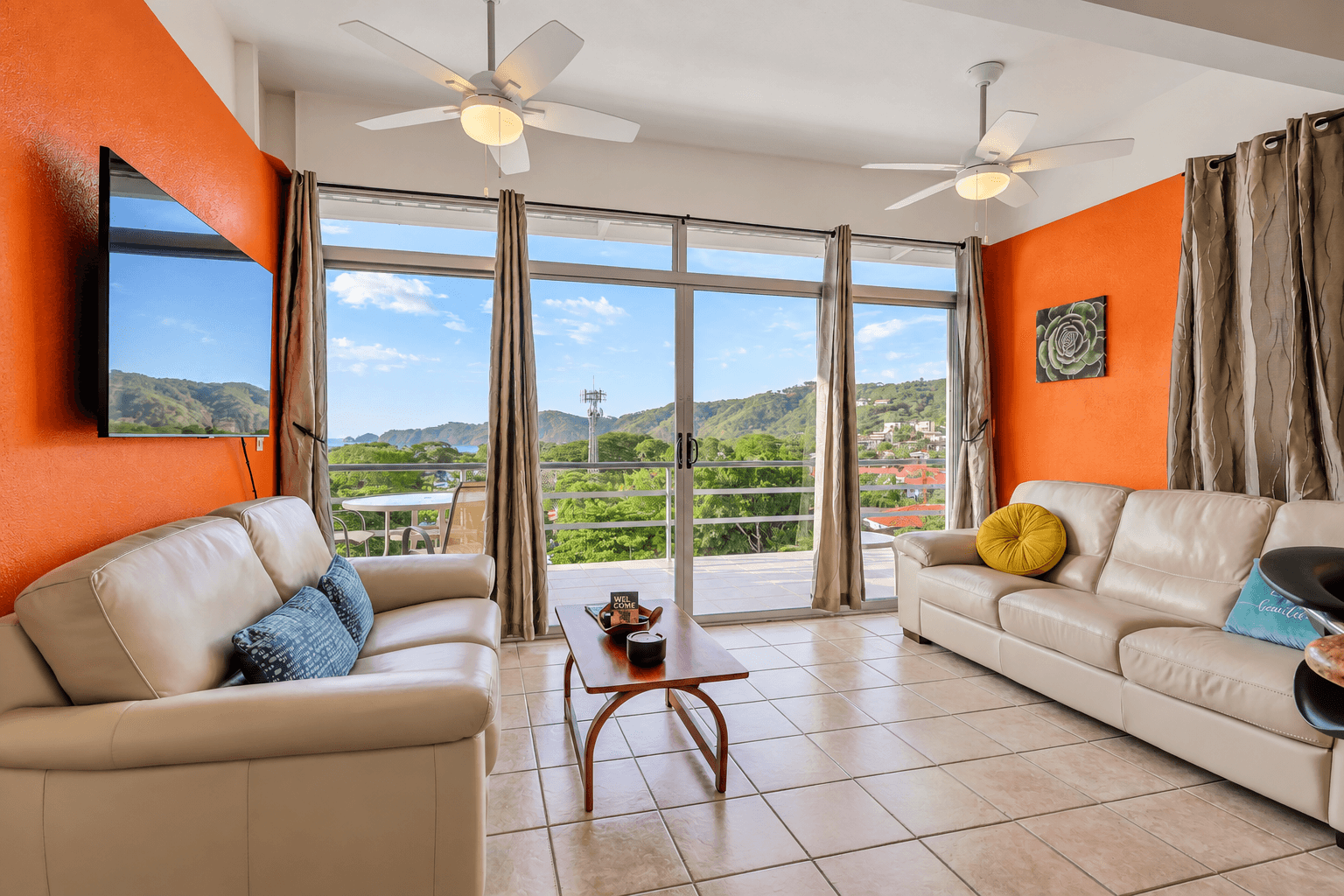 Living room with balcony access at Tucanes 12 vacation rental in Playas del Coco