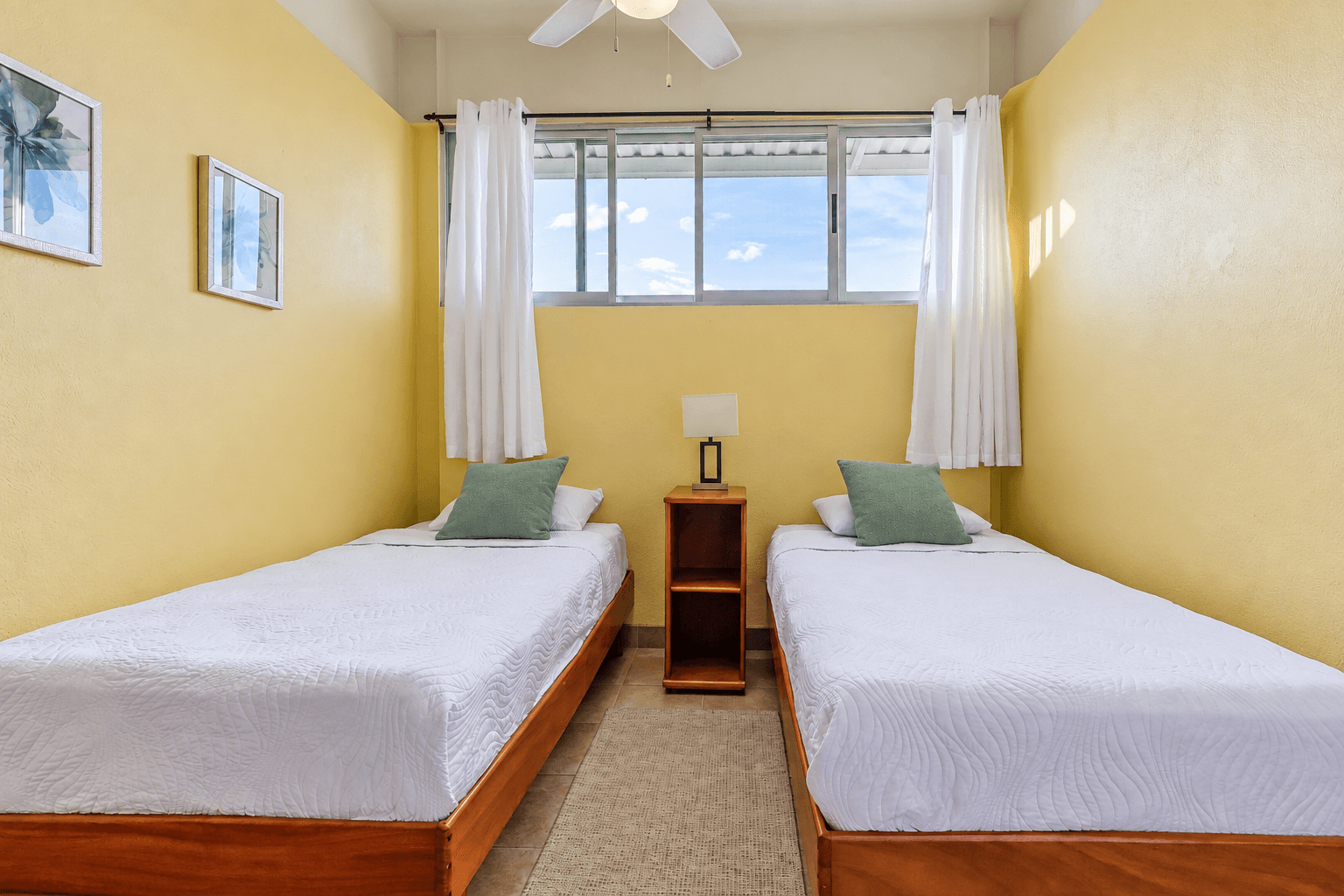Guest bedroom with two twin beds at Tucanes 12 vacation rental in Playas del Coco