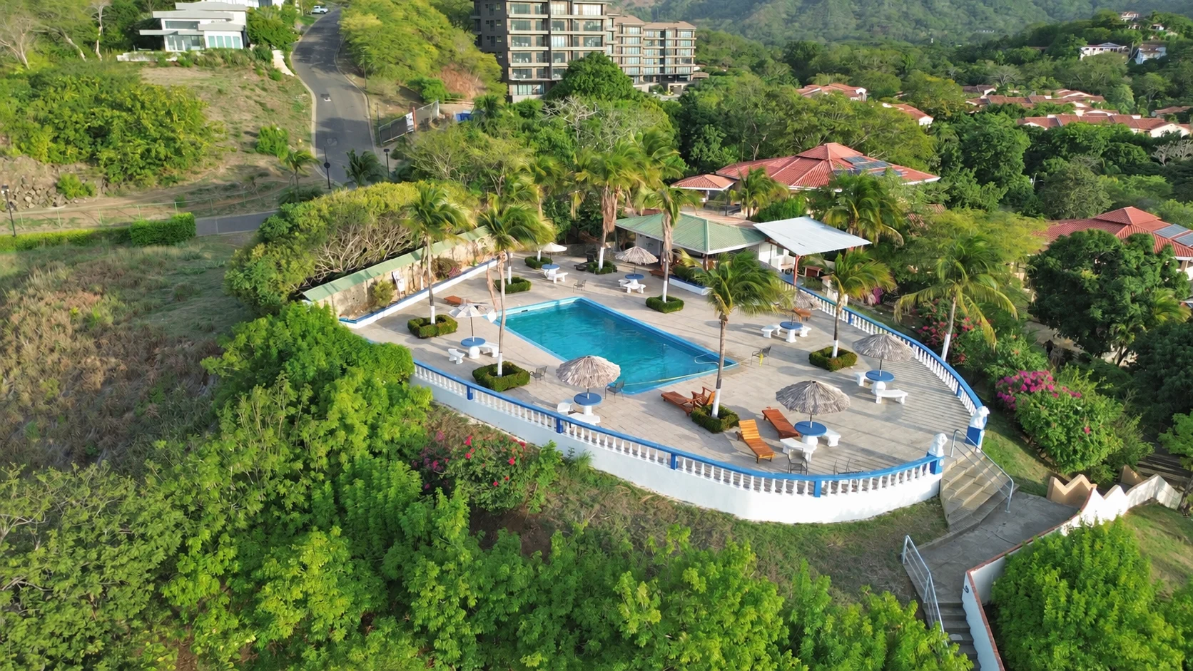 Community pool and landscaped grounds at Tucanes 12 vacation rental in Playas del Coco