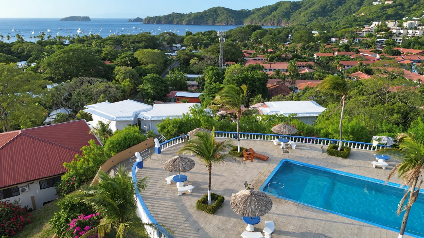 Community pool with bay beyond at Tucanes 12 vacation rental in Playas del Coco
